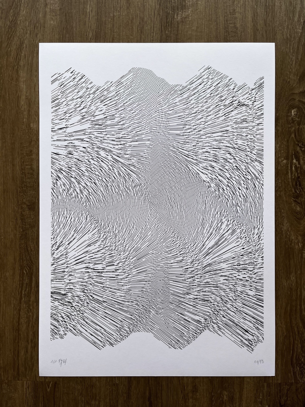 A white sheet on a wooden table, filled with thousands of short black lines that flow and swirl like water between two wavy edges.