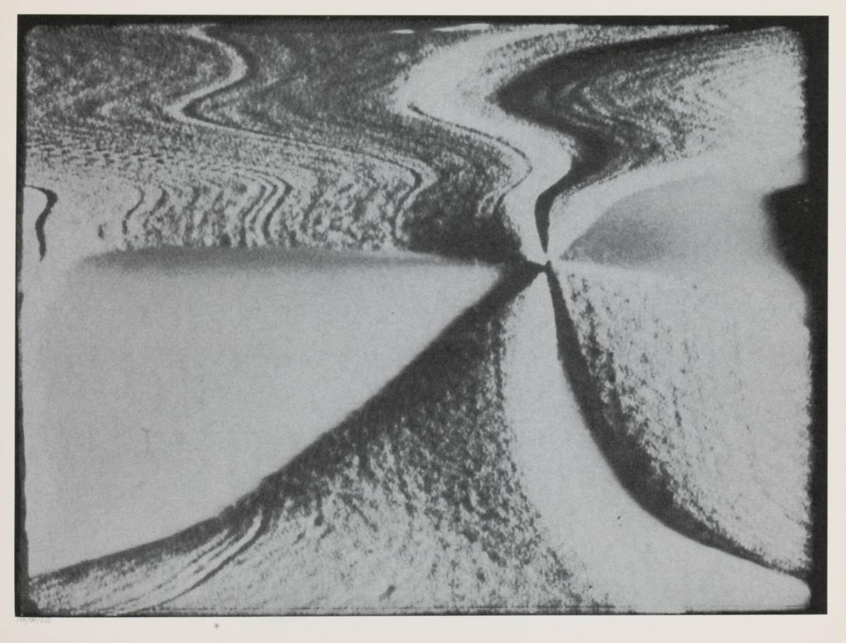 A black and white print in which a photographic image has been stretched into flowing wave forms that converge at the centre, so that the original picture is almost dissolved.