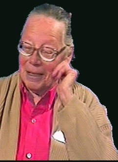 Vera Molnár in 1996, an older woman with short grey hair and glasses, in a pink shirt and a beige cardigan.