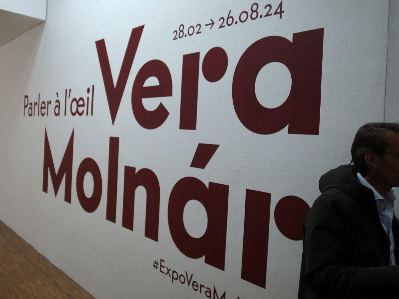 A white wall with the words Vera Molnár and Parler à l'œil in large dark red letters, and the dates 28.02 – 26.08.24.